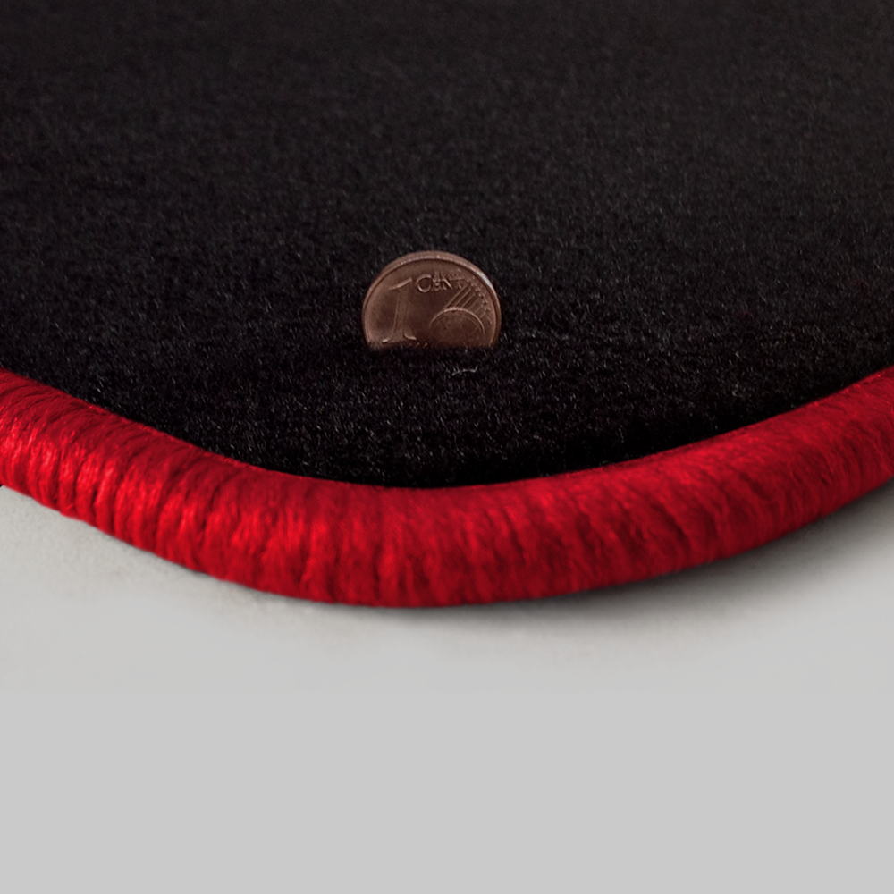 Eine Ecke als Beispiel einer Fussmatte Velours schwarz mit Rand in rot.